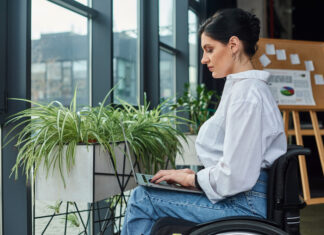 Een arbeidsongeschiktheidsverzekering: hoe werkt dat? vrouw in rolstoel aan het werk