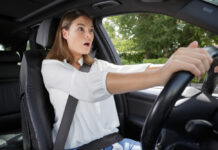 Wanneer is het verplicht om een autogordel te dragen? Lees het hier vrouw geschrokken achter het stuur van een auto