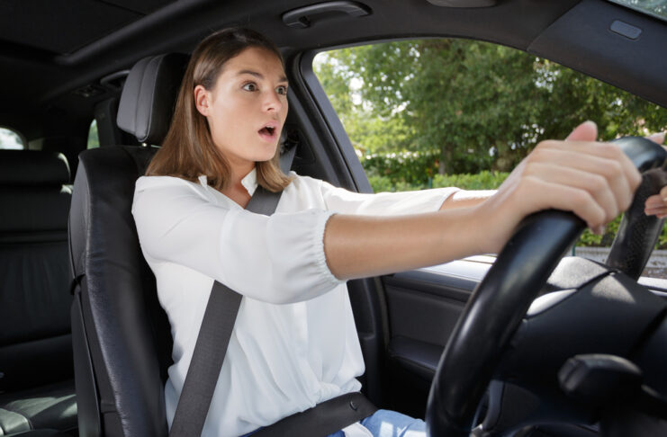 Wanneer is het verplicht om een autogordel te dragen? Lees het hier vrouw geschrokken achter het stuur van een auto
